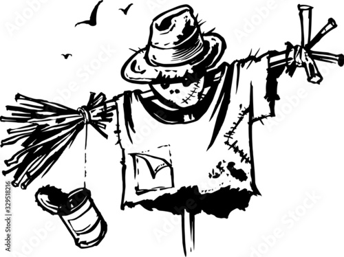 funny scarecrow in a torn shirt and a straw hat