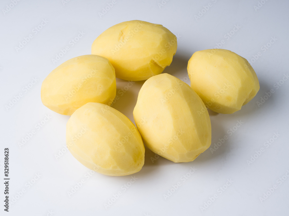 Several peeled potatoes on a white surface. Preparation for cooking. Studio photography Several peeled potatoes on a white surface. Preparation for cooking. Studio photography