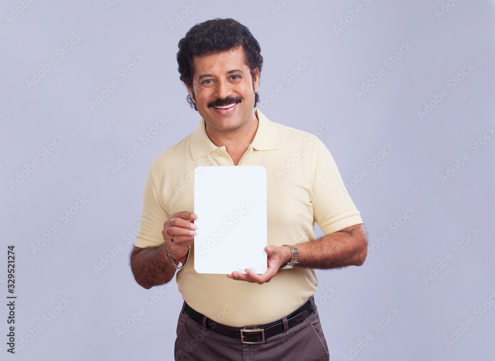 Man in happy mood showing a small placard in hand. Man in happy mood showing a small placard in hand.