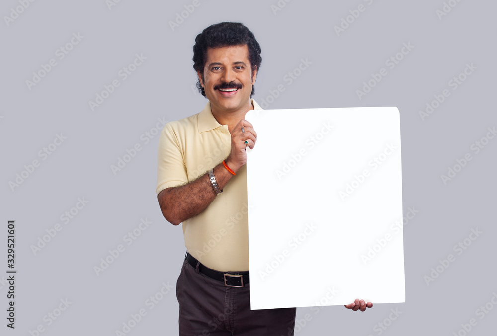 Man in happy mood holding a rectangular shaped placard in hand. Man in happy mood holding a rectangular shaped placard in hand.
