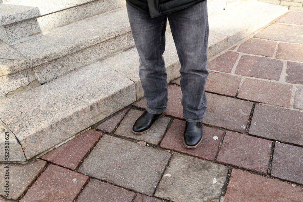 Legs in jeans and black shoes at the granite steps Legs in jeans and black shoes at the granite steps