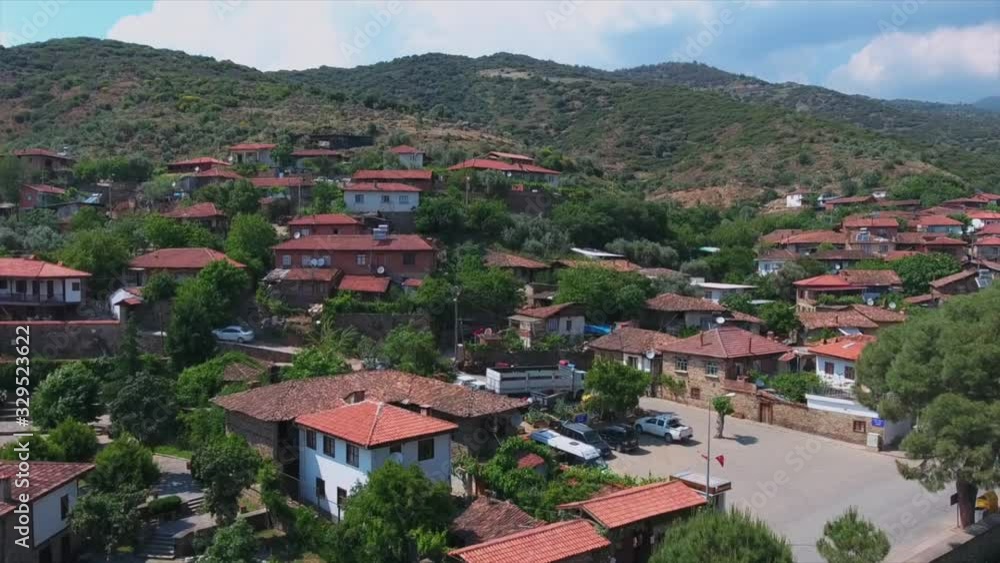 Aerial view of Birgi Odemis with a drone 4K. The old historical village which was built on the skirts of the mountain ,has pine trees and stone houses with a red tiled roof. Aerial view of Birgi Odemis with a drone 4K. The old historical village which was built on the skirts of the mountain ,has pine trees and stone houses with a red tiled roof.