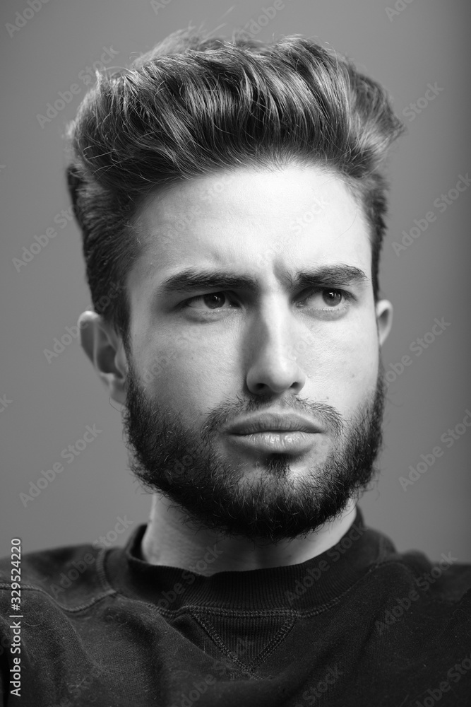 Close-up black and white portrait of a young handsome Caucasian male in studio. A man shows different human emotions. Close-up black and white portrait of a young handsome Caucasian male in studio. A man shows different human emotions.