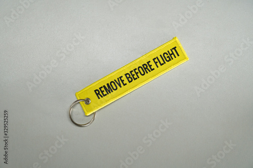 Bright yellow color remove before flight airplane safety label isolated on white close up.