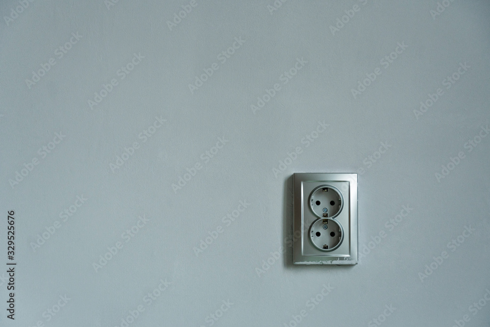 Close up view of double grey electric socket on grey plain wall. Close up view of double grey electric socket on grey plain wall.