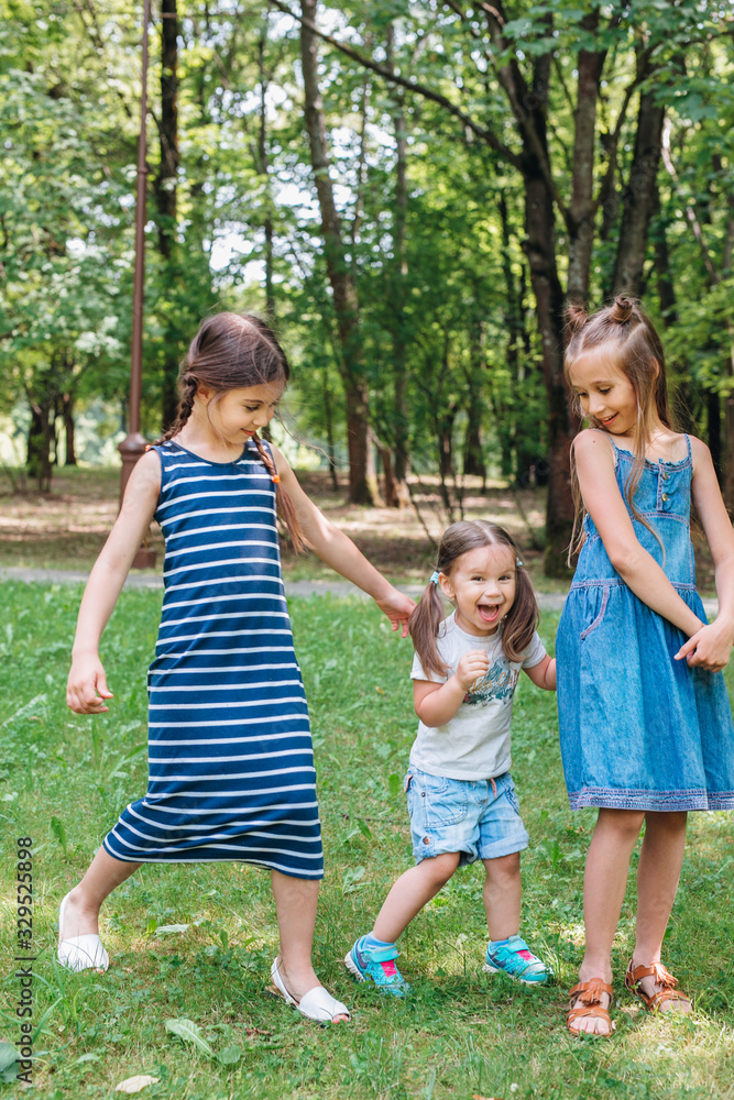 Obraz premium Happy active kids playing on green grass in spring park