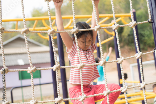 happy little asian girl child having fun to playing in the playground in summer time with smile and laughing healthy, funny smiling face adorable lovely female kid. happy vacation lifestyle concept.