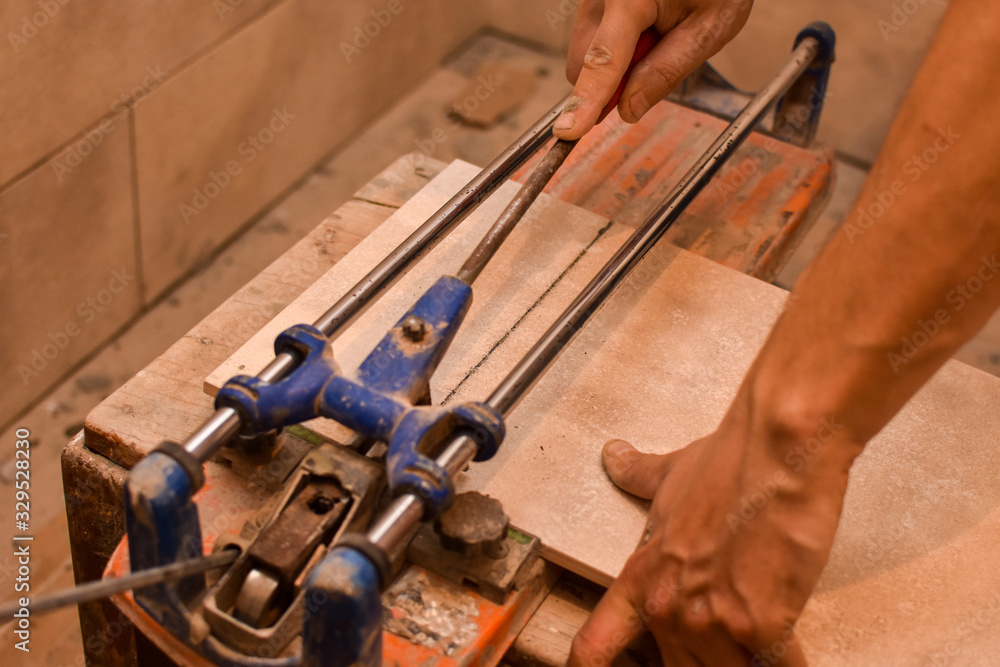 Tiler cutting ceramic with machine. Concept of building and home renovation Tiler cutting ceramic with machine. Concept of building and home renovation