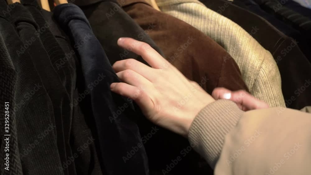 Close Up Of a Woman Hands Choosing clothes in a Thrift shop Close Up Of a Woman Hands Choosing clothes in a Thrift shop