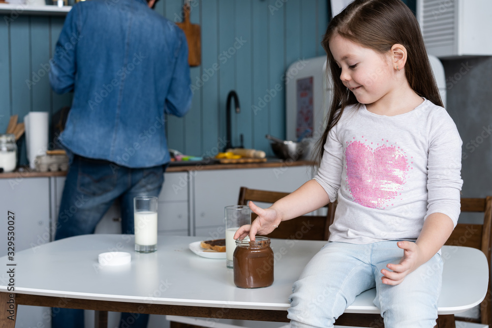 happy smiling girl eating sandwich for breakfast and looking at the camera in the kitchen happy smiling girl eating sandwich for breakfast and looking at the camera in the kitchen