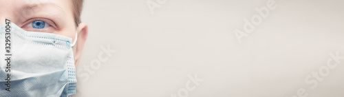 фотографія Masked caucasian woman half face with copy space web banner: pandemic concept an