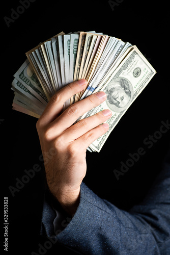 Male hand holding bunch of dollar bills