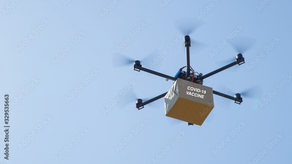 CLOSE UP Unmanned helicopter carries a brown package containing COVID-19 vaccine CLOSE UP Unmanned helicopter carries a brown package containing COVID-19 vaccine