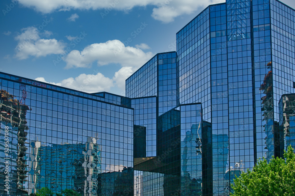A blue glass financial center reflecting city