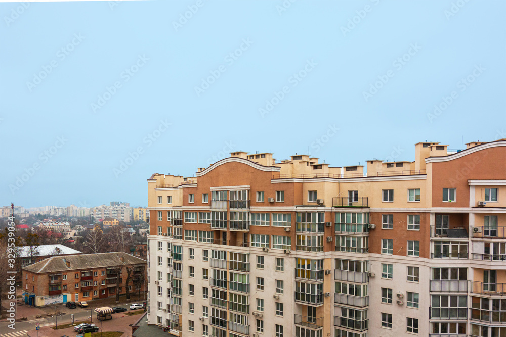 Modern urban architecture cityscape view under blue sky at daytime. Building roofs and facades in brown colors. Mortgage to buy private apartment concept