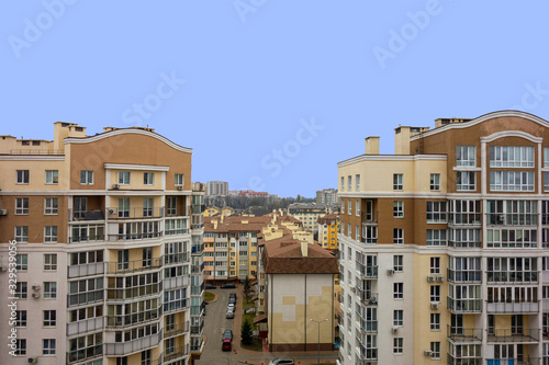Modern urban architecture cityscape view under blue sky at daytime. Building roofs and facades in brown colors. Mortgage to buy private apartment concept