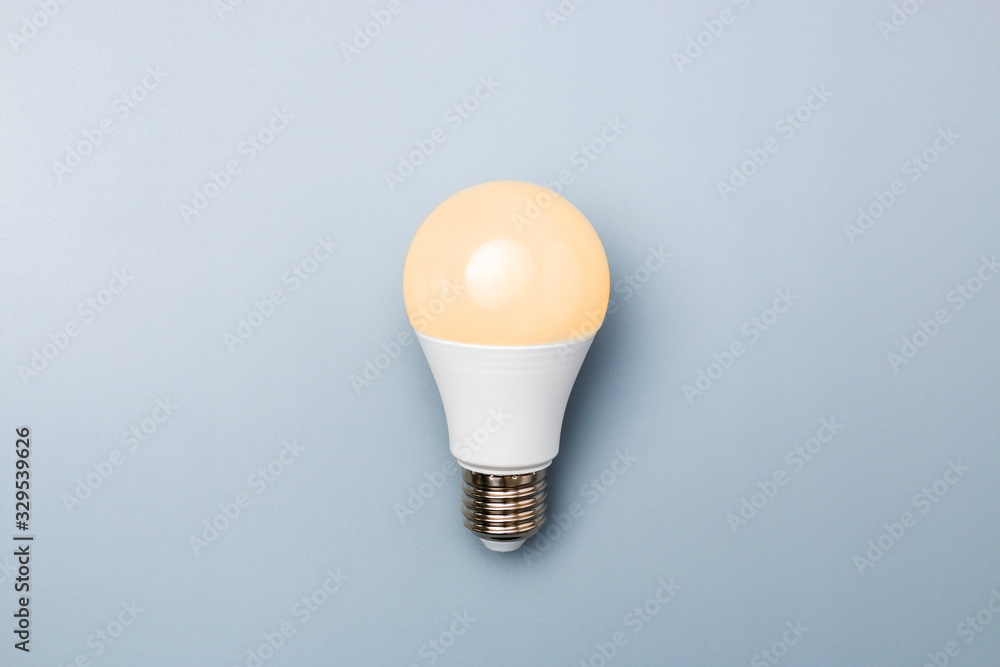 led bulb with orange light against a grey background with copy space. energy efficiency concept led bulb with orange light against a grey background with copy space. energy efficiency concept