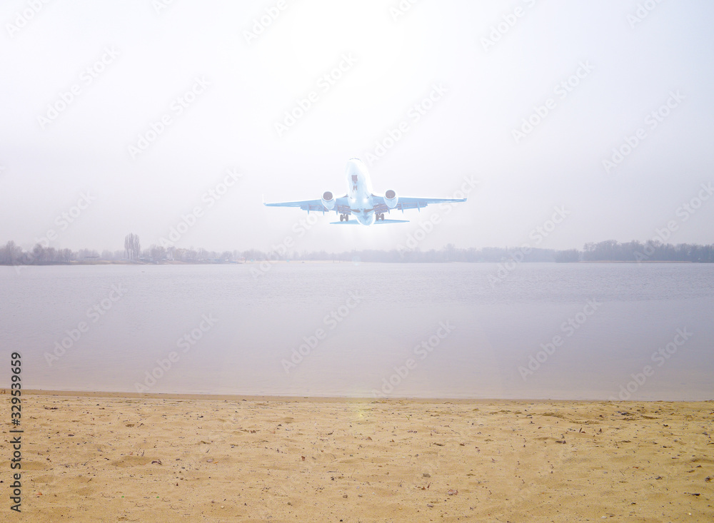 Fototapeta premium Airplane over the lake and sand outside the city. Transport