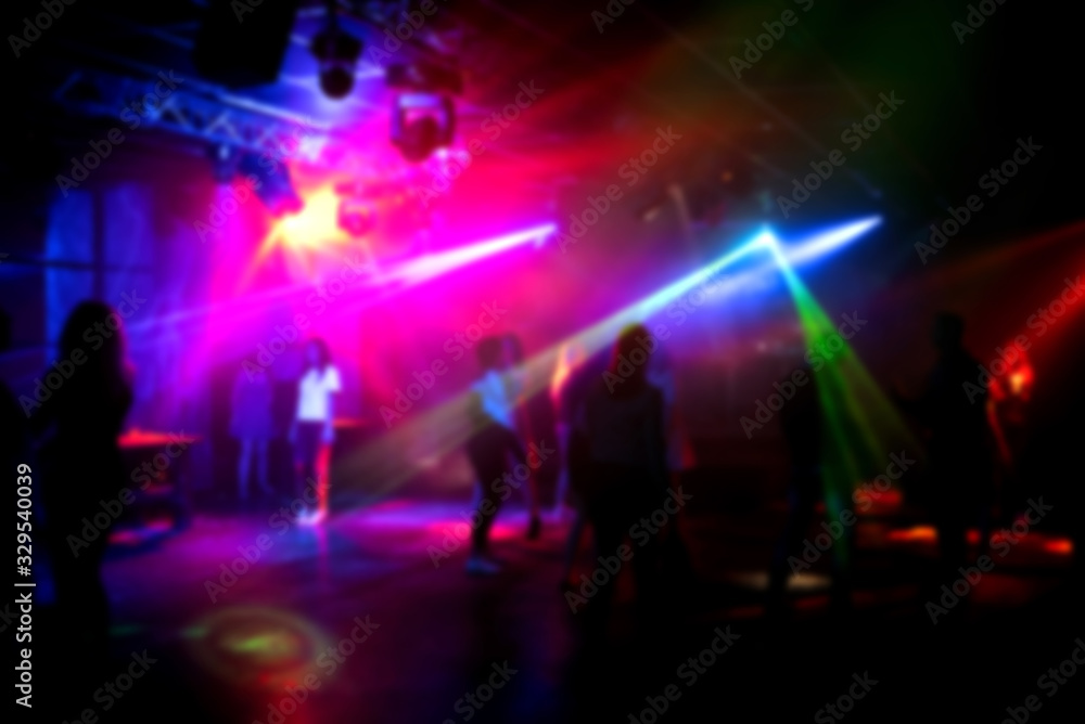 Fototapeta premium blurred silhouettes of people dancing in a nightclub