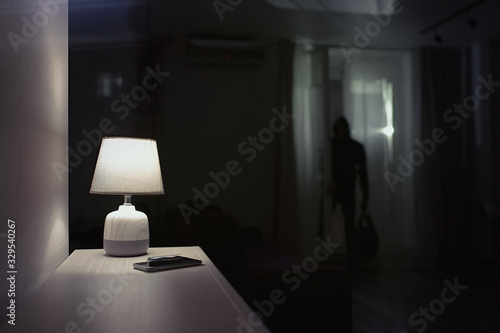Fototapeta Burglar inside of a house with flashlight