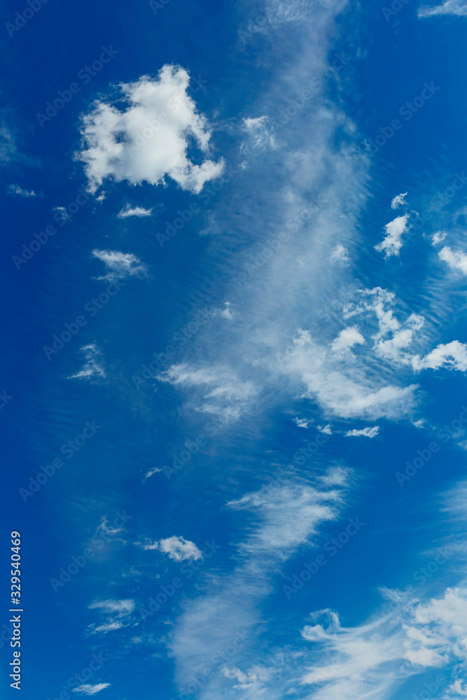 a group of white cirrus clouds in the blue sky as a natural background