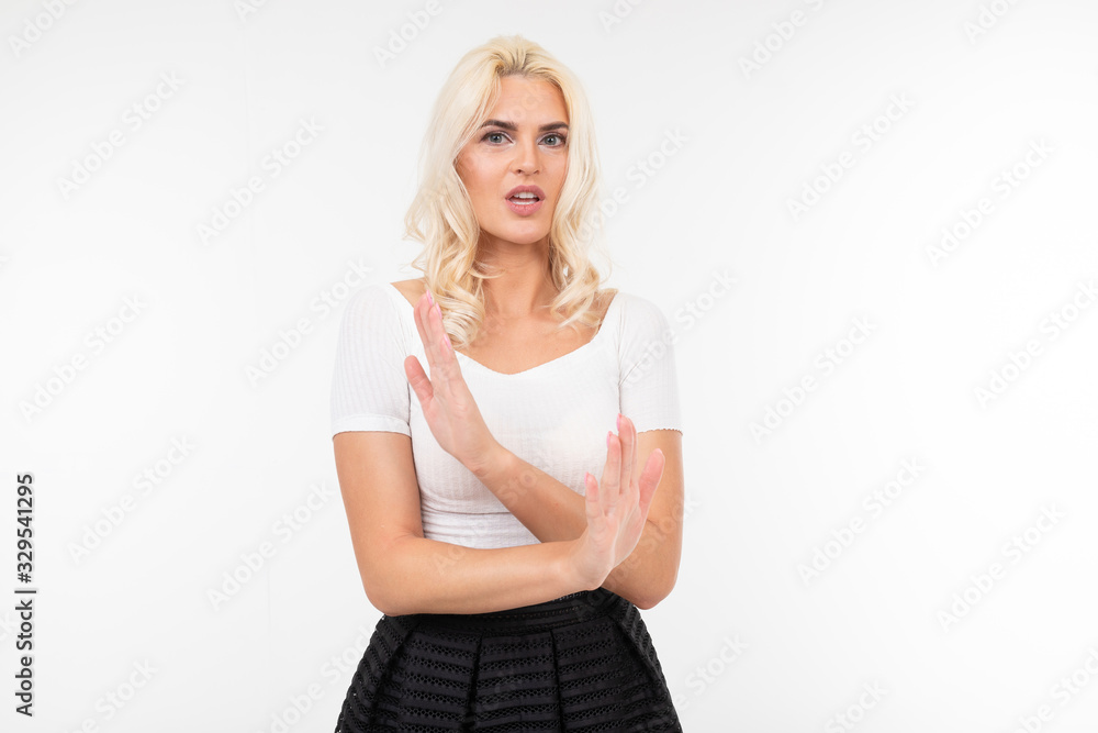 indignant woman in white t-shirt mahay with hands in denial on a white background with copy space indignant woman in white t-shirt mahay with hands in denial on a white background with copy space