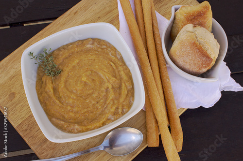 Bilde på lerret Vegetables soup with bread and baked bread on wooden table with natural light