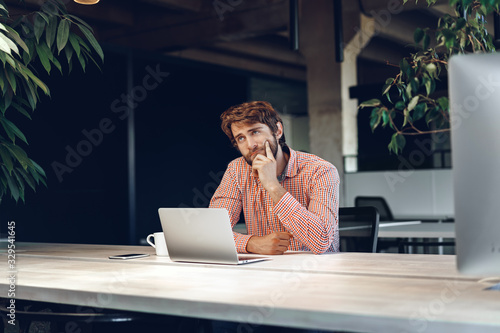Billede på lærred Puzzled thoughtful businessman sitting at his working table in an office