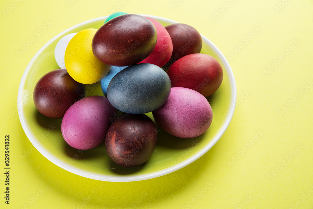 Colorful Easter eggs as an attribute of Easter celebration on the yellow plate. Colorful Easter eggs as an attribute of Easter celebration on the yellow plate.