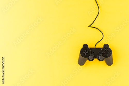 Video game controller on yellow background with copyspace. Computer player concept. Top view
