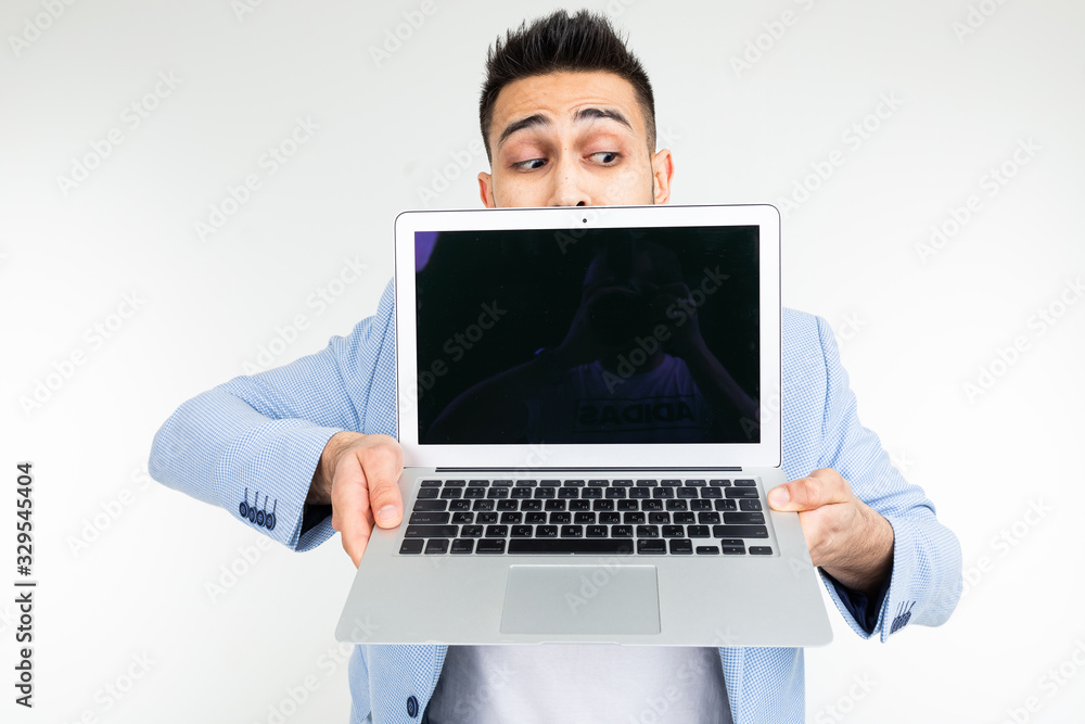 stylish successful man in a jacket demonstrates a laptop screen with space for advertising on a white studio background stylish successful man in a jacket demonstrates a laptop screen with space for advertising on a white studio background