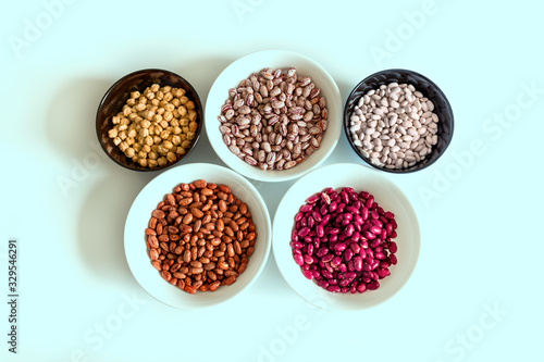 Phaseolus. Bright multi-colored beans, mung beans and chickpeas in ceramic cups. A complete source of vegetable protein in vegetarianism. The concept is healthy eating.