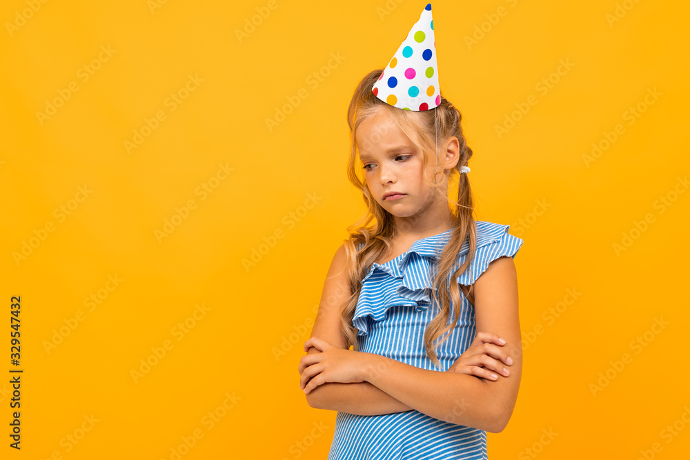 Beautiful girl with long hair has a birthday today, picture isolated on yellow background