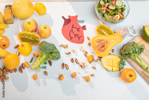 Fototapeta Naklejka Na Ścianę i Meble -  Human heart drawing with variety of healthy fresh fruits and vegetables on the table. Concept of balanced nutrition for heart health