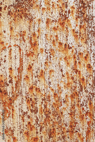 Beige peeling cracked paint on an old abandoned rusty stained sheet of metal. Abstract modern trendy texture background