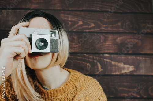Photos Young woman taking photographies with an analog camera