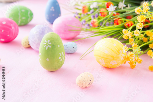 Easter eggs with wild flowers on a wooden pink table background