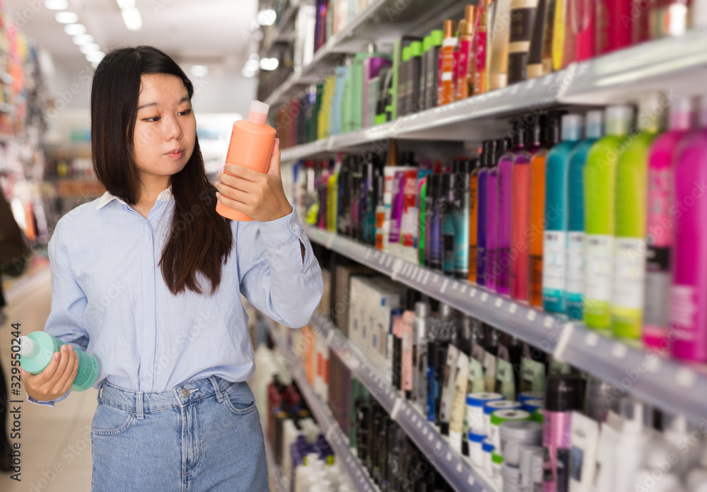Asian female customer selecting shampoo