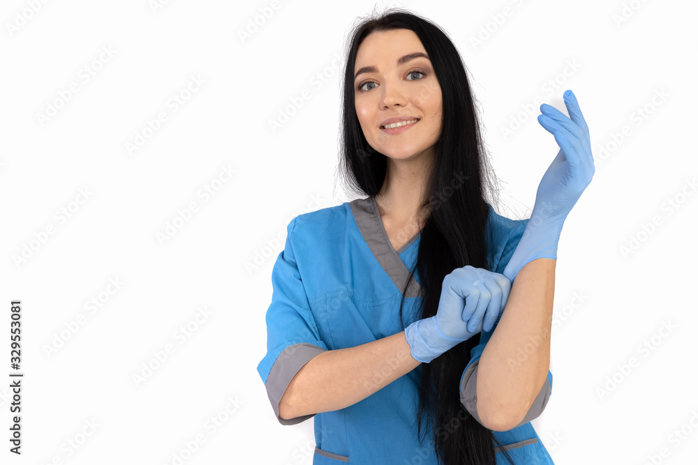 Woman doctor in blue uniform puts on gloves Woman doctor in blue uniform puts on gloves