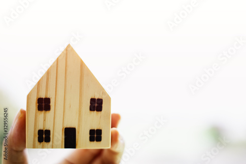 Hand holding wooden house m...