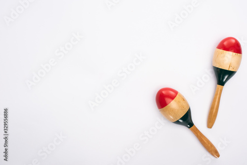 Top view of wooden colorful maracas on white background