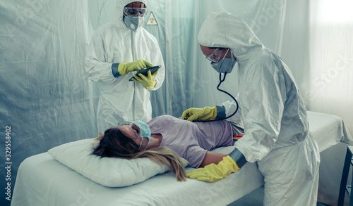 Photos Doctors with bacteriological protection suits attending a patient