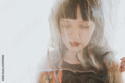 Young exotic woman posing near a window with backlight