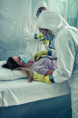 Doctors with bacteriological protection suits attending a patient photo