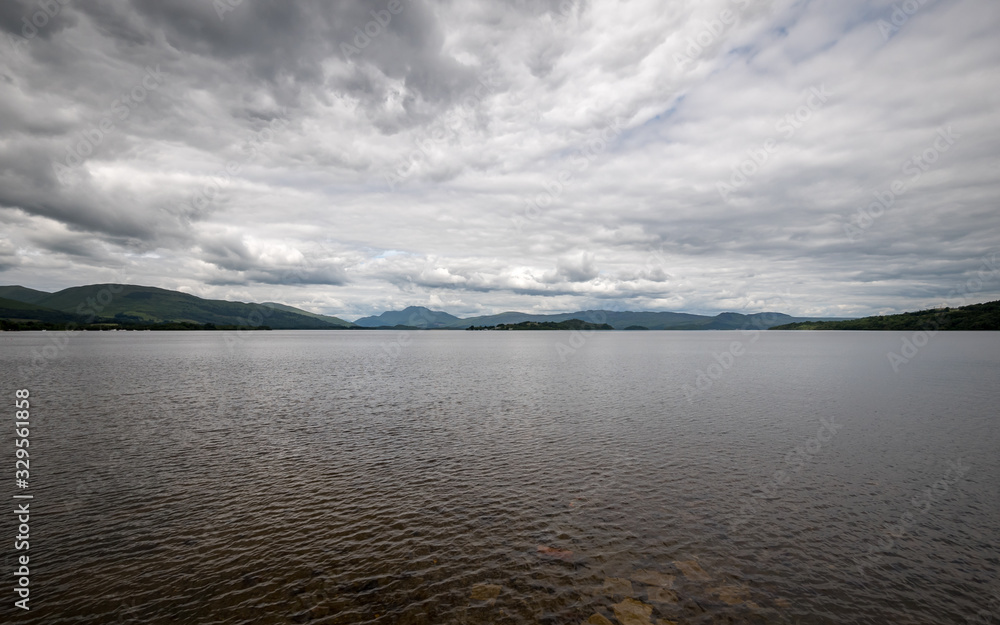 Loch Lomond, Scotland. A wide angle view over the waters of the southern shores of Loch Lomond set against a stormy grey sky.
