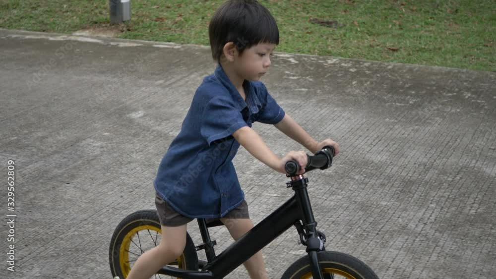 kid playing balance bike on street road kid playing balance bike on street road