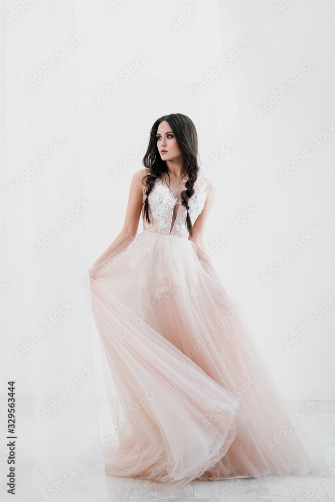 Portrait of bride. A young attractive brunette woman with long black hair in braids. White wedding dress and beige hat. Rustic style, bouquet of wheat spikes. Portrait of bride. A young attractive brunette woman with long black hair in braids. White wedding dress and beige hat. Rustic style, bouquet of wheat spikes.
