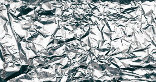 Wrinkled silver foil texture. Grunge metal background