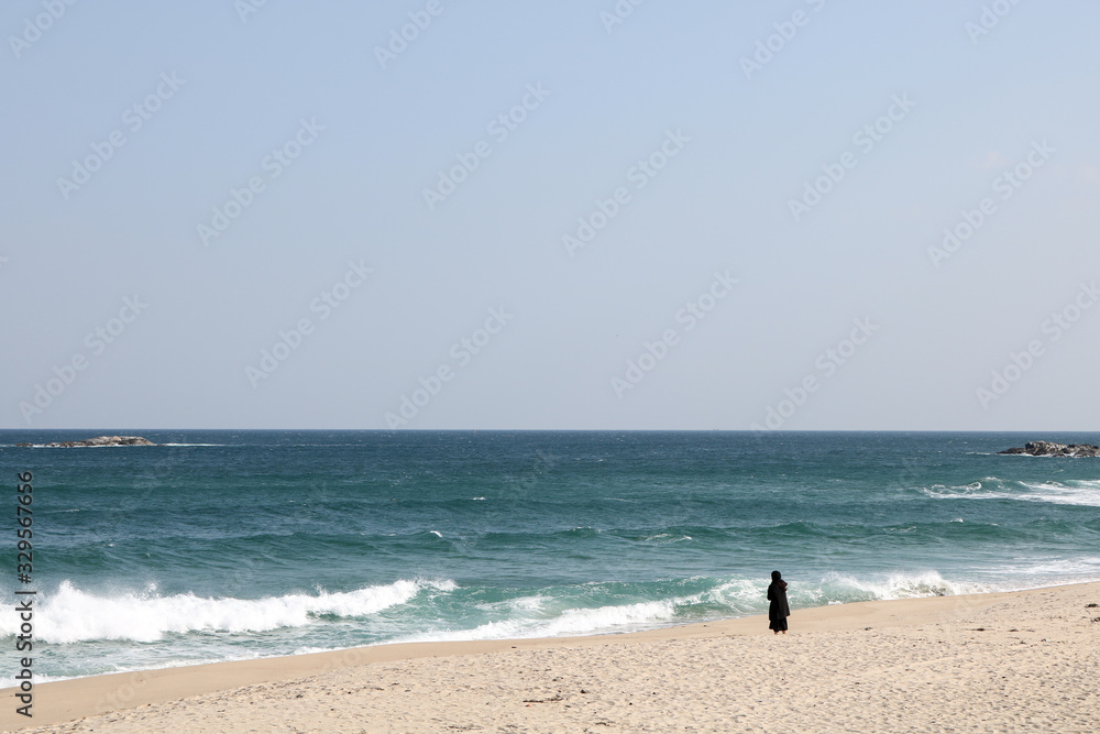 Woman alone at the sea.