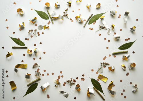 Golden confetti on a white background. Gold foil is arranged in a circle.